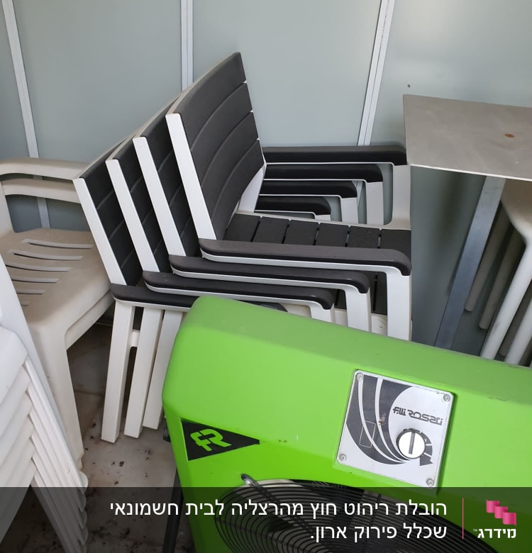 כיסאות פלסטיק מוערמים ומאוורר ירוק גדול